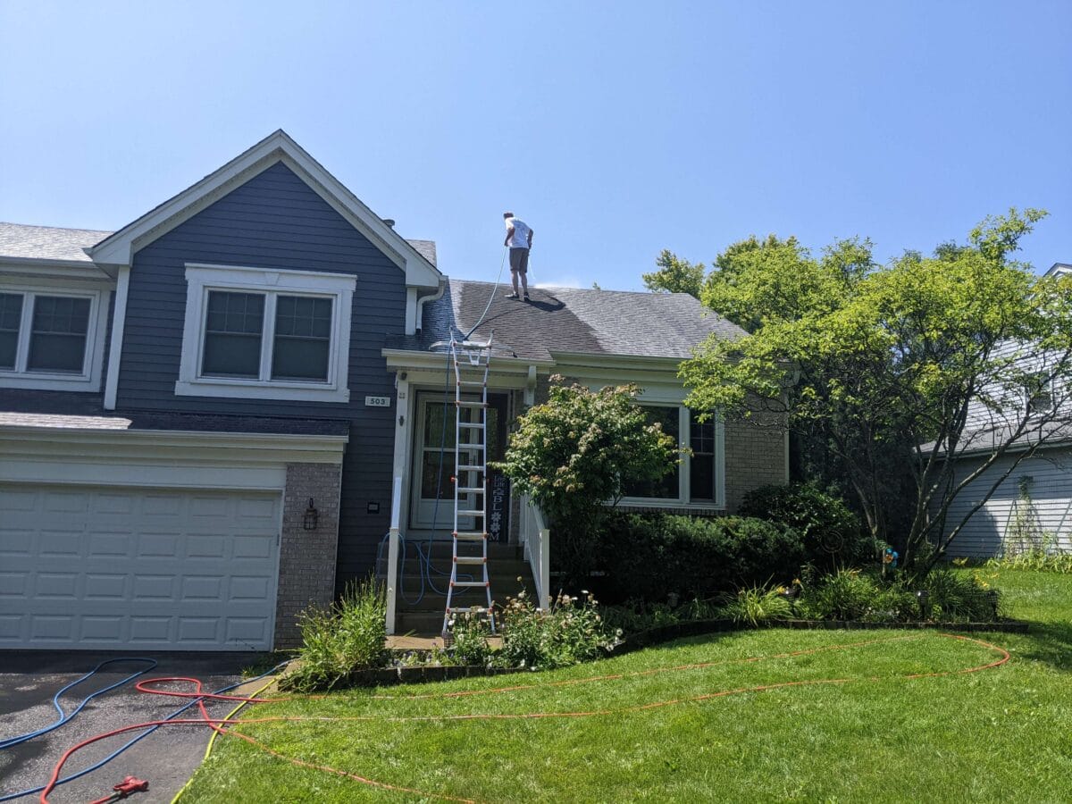 Z Pressure Washing owner standing on a house roof performing a Roof Treatment.